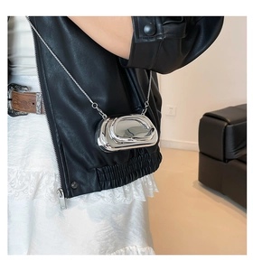 Chic silver metallic liquid-shaped mini bag with chain strap worn by a model