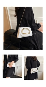 Détail d'un sac bandoulière en cuir blanc avec boucle dorée et chaîne fine