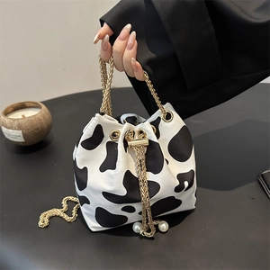 Fashionable cow print bucket bag for women with gold chain strap and pearl details