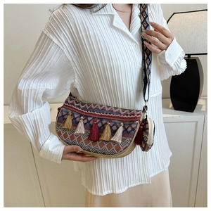 Détail du sac à bandoulière tissé bohème avec pompons colorés et petit porte-monnaie