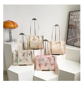 Detailed close-up of Chinese embroidery tote bags with tassels and floral bird patterns