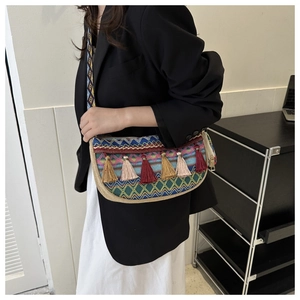 Gros plan sur le sac bohème tissé avec des glands colorés et des broderies géométriques