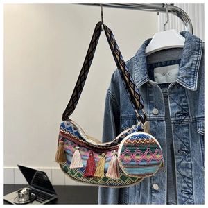 Détail du sac croissant tissé bohème avec pompons colorés faits main et bandoulière jacquard