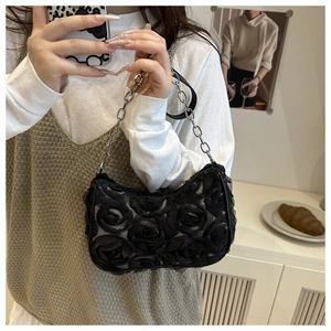 Close-up of black 3D rose textured shoulder bag with elegant silver metal chain strap