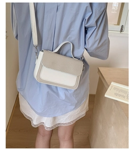 Detail showing white PU leather and canvas woven flap of the elegant crossbody bag