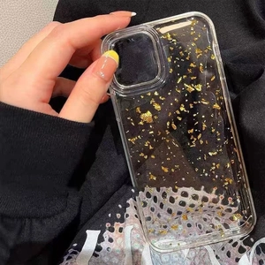 Transparent iPhone case with gold foil sparkles held in hand over black background