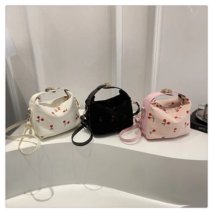 Detailed close-up of corduroy crossbody bags with red cherry embroidery in three colors
