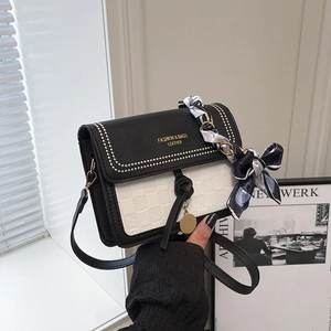 Chic black and white contrast leather crossbody bag with decorative scarf and gold hardware