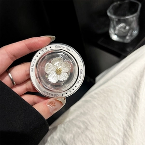 Macro detail of a transparent phone grip featuring a white resin flower and Gift For You text