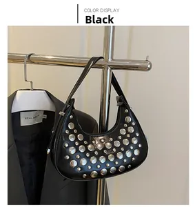 Detail view of black crescent moon bag with silver rivets and sleek leather texture