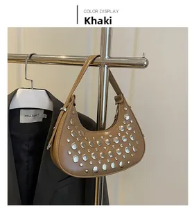Close-up of khaki crescent hobo bag with silver studs and smooth synthetic leather texture