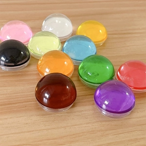 Colorful crystal sphere phone socket grips displayed on a minimalist light wood surface