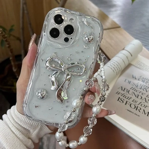 Detail of white wave phone case with silver bow and pearl bead hand strap for iPhone