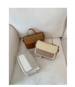 Three minimalist crossbody bags in brown and beige colors on a white soft sofa
