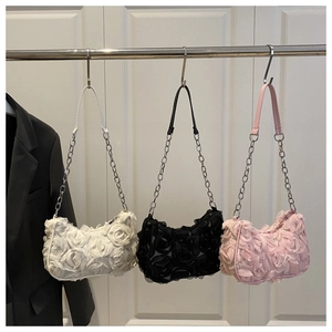 Detailed view of 3D lace flower textures on shoulder bags in white, black and pink