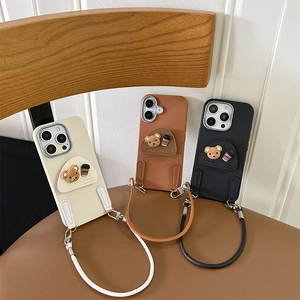 Three leather-textured iPhone cases with 3D bear icons and matching hand straps