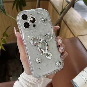 Detail of wavy iPhone case with silver bow, metallic beads, and glitter foil decoration