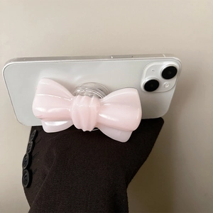 Détail d'un support de téléphone en forme de nœud rose clair avec fini perlé brillant