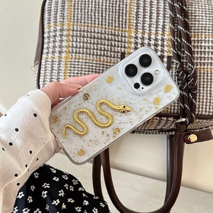 Detailed view of clear iPhone case with embedded gold foil, 3D snake, and dollar signs