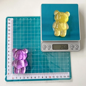 Expandable crystalline textured bear phone grip shown on measurement scale and mat