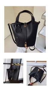 Macro shot of black lychee leather bucket bag with gold lock and smiley charm detail