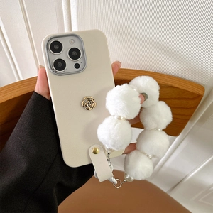 Detailansicht einer beigen iPhone-Hülle aus Silikon mit weißem Plüschband und Kamelie.