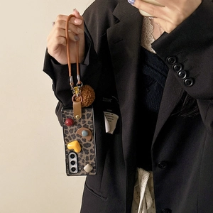 Custodia Samsung Z Flip leopardata con cinturino in pelle marrone e decorazioni a cuore 3D
