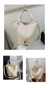 Close-up of cream lychee leather bucket bag with gold padlock and charm details