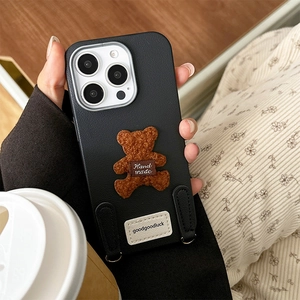 Detailed view of 3D plush teddy bear and leather texture on a black iPhone case