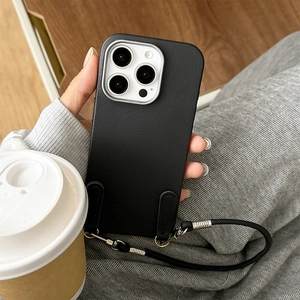 Detail of black leather phone case with dual ring loops and adjustable long crossbody strap