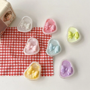 Detailed view of colorful iridescent resin bow charms in seven soft pastel shades