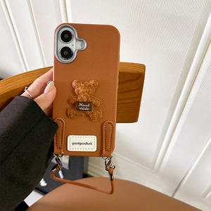Detail of brown faux leather phone case with 3D plush bear and goodluck wrist strap