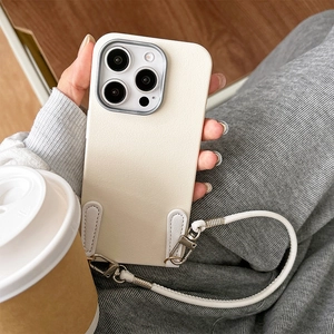 Detail of cream leather iPhone case with matching hand strap and silver hooks in life-style setting