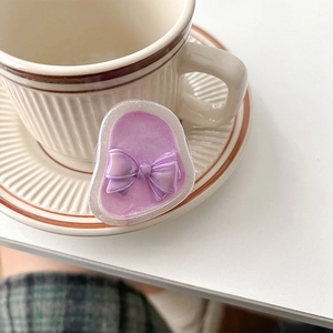 Detailed macro view of a lavender iridescent bow phone socket with pearlescent resin finish