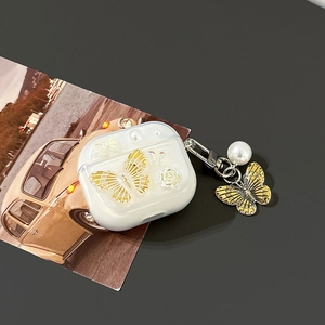 Vista detallada de la mariposa 3D y el llavero de perla en la funda para AirPods.