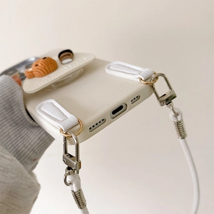 Detail of cream leather phone case with 3D bear, coffee cup charm and lanyard