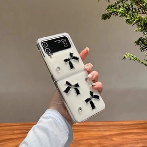 Detailansicht der Galaxy Z Flip Hülle mit weißem Finish und eleganter schwarzer Schleife