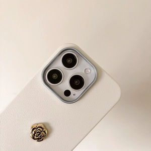 Detailansicht einer weißen Leder-iPhone-Hülle mit goldener Kamelienblüte Dekoration.