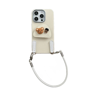 Cream leather iPhone case with a knitted bear, coffee cup charm, and white crossbody strap