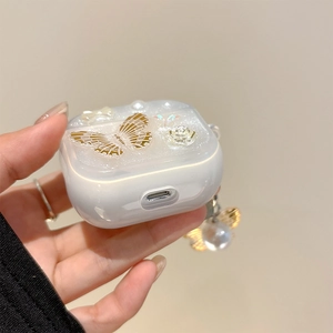 Vista detallada de la funda blanca para AirPods con mariposa 3D dorada y perlas