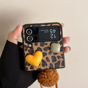 Dettaglio custodia Samsung Z Flip leopardata con cuori in resina e pompon in pelliccia