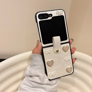 Vue détaillée de la coque beige en cuir Galaxy Z Flip 6 avec charms cœur et nœud en perle