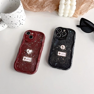 Close-up of glitter iPhone case with wave edges and smile heart pendant detail