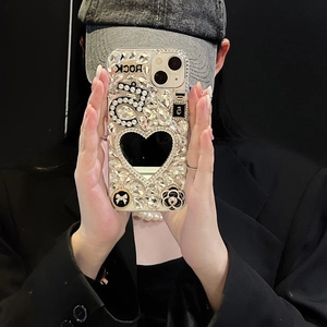 Macro detail of luxury iPhone case with heart mirror, rhinestones, and camellia flower