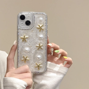 Détail d'une coque iPhone avec étoile de mer dorée, perles et bordures en strass