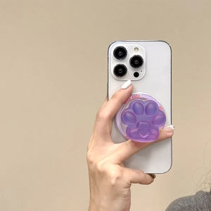 Detailed view of purple cat paw phone socket mount with heart-shaped pad on a white phone