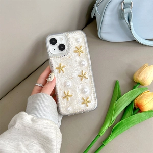 Détail d'une coque iPhone 16 Plus avec perles, étoile de mer dorée et strass chic