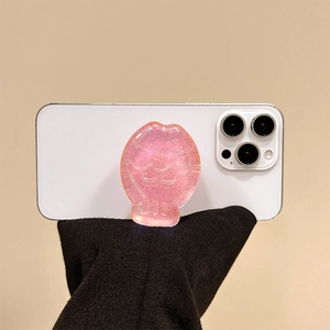 Detailed macro view of pink glitter shell phone grip on a white smartphone