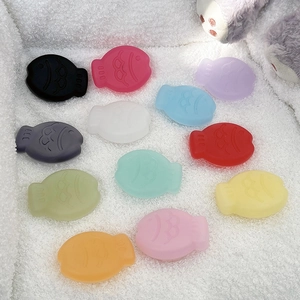 Colorful fish-shaped silicone pop socket stands for mobile phones on soft plush background