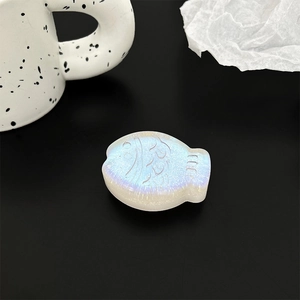 Macro shot of 3D fish phone grip with iridescent glitter finish on black background